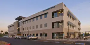 Modern office building with parked cars outside.