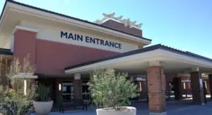 Building with sign "Main Entrance" and plants.
