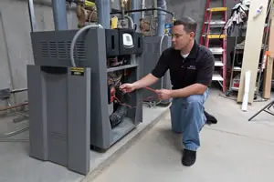 Technician inspecting a large furnace system.