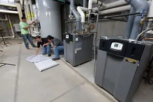 Technicians examining industrial equipment and blueprints.