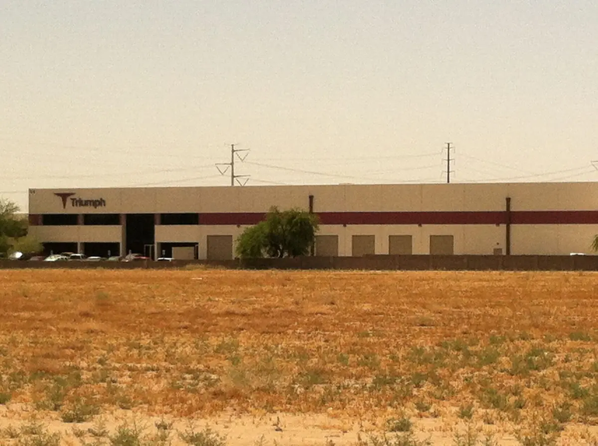 Warehouse building with arid landscape in foreground.