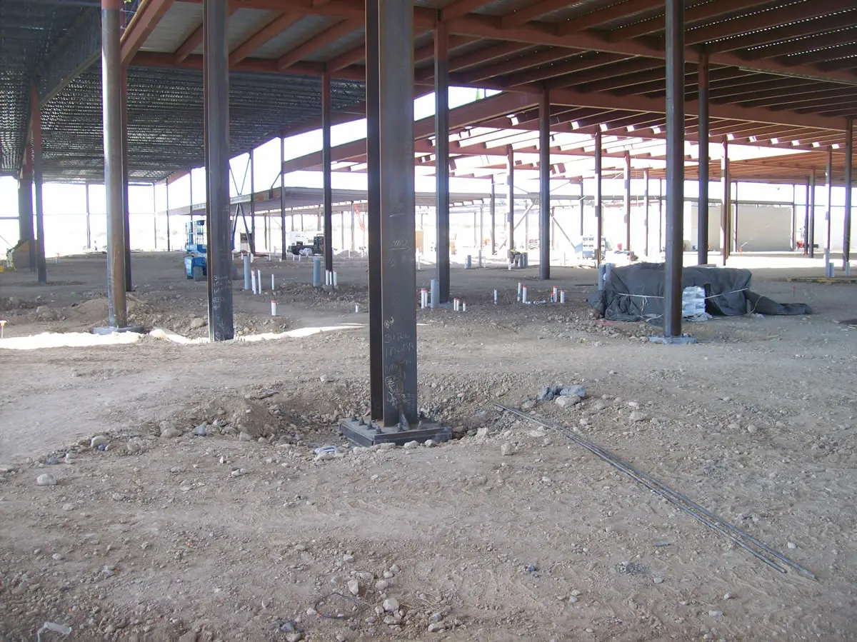Steel framework at construction site with dirt floor.