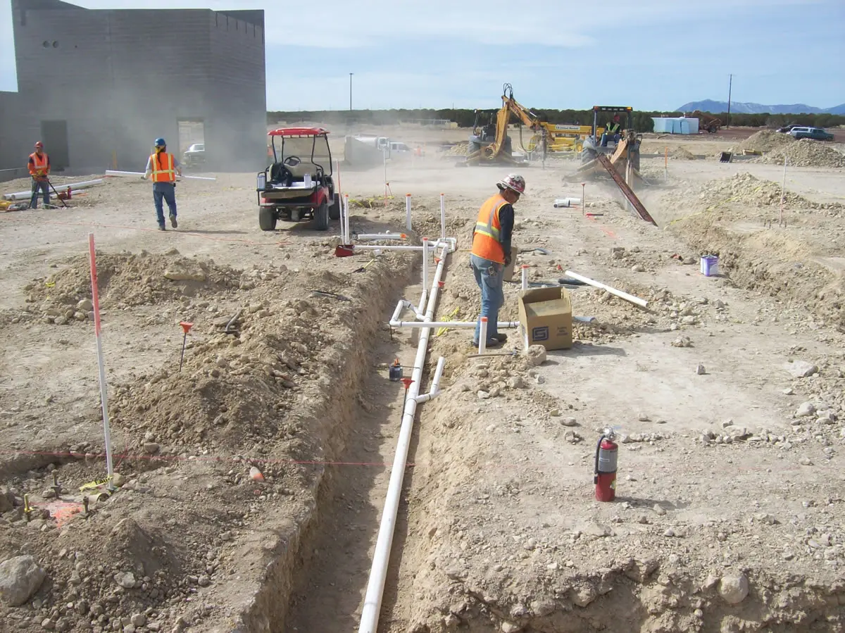Construction workers installing underground utility pipes.