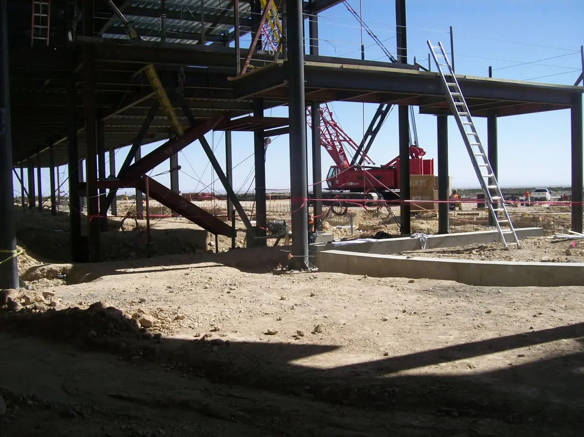 Construction site with metal framework and ladder.