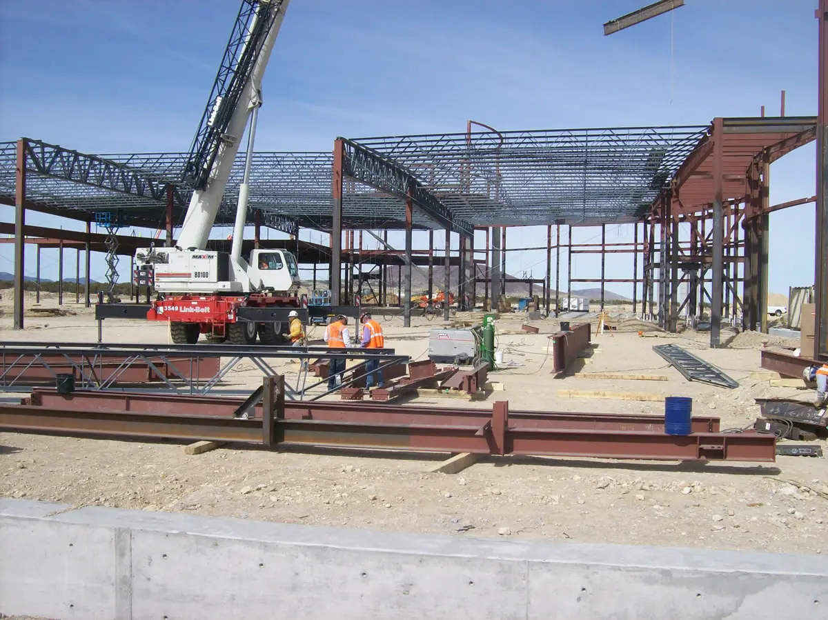 Construction site with steel framework and crane.