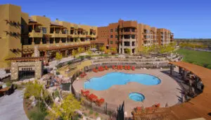 Hotel with pool and surrounding landscape view.