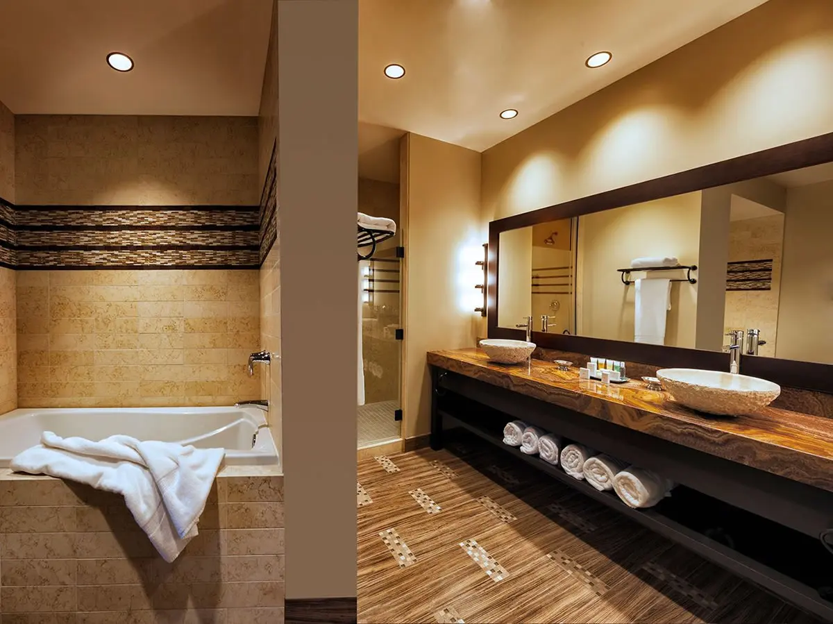 Modern bathroom with tub and double sinks.