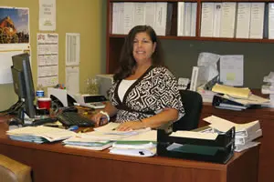 Woman smiling at desk in office.